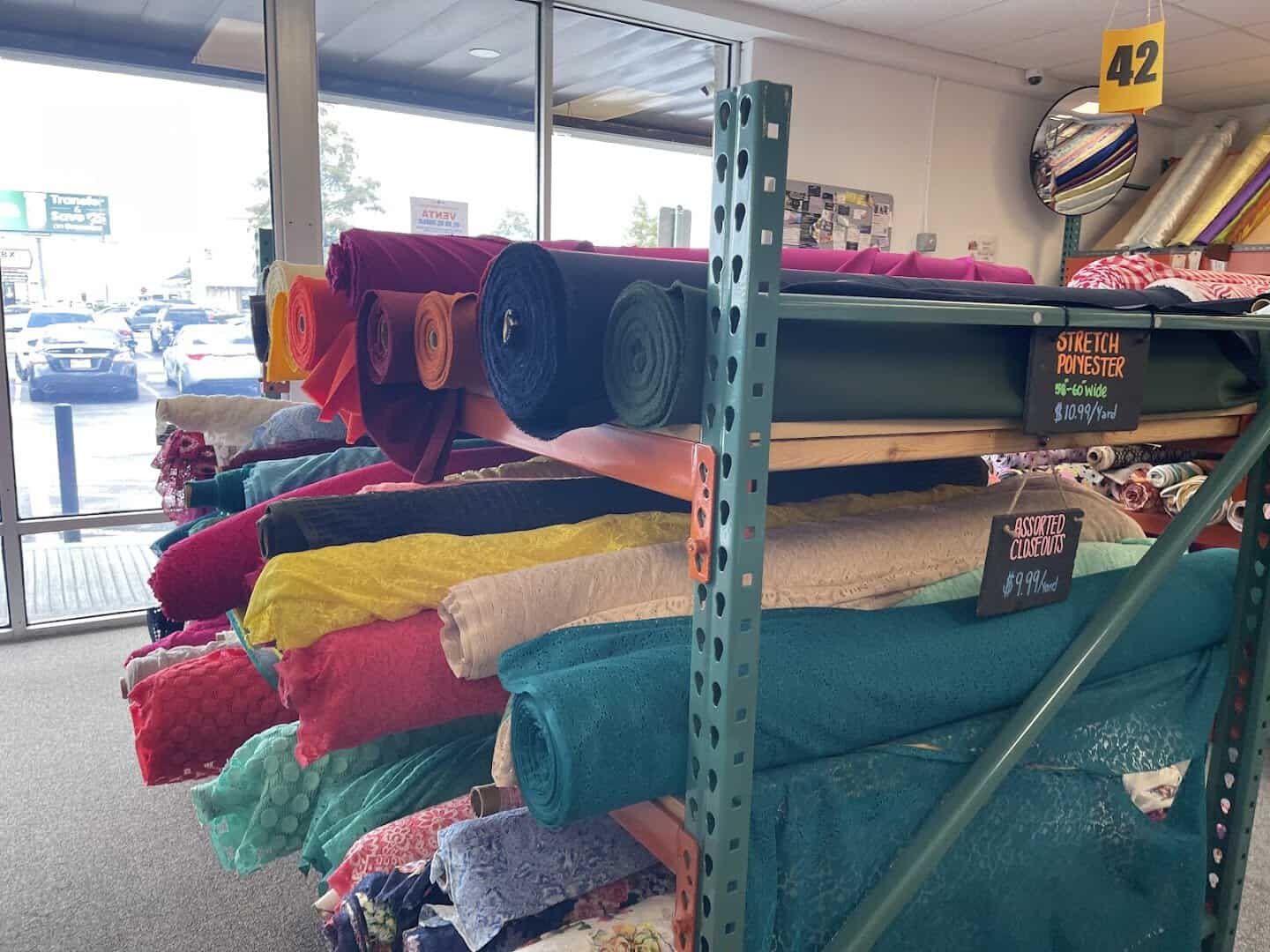 Colorful folded fabric bolts on warehouse racks at Fabrictopia in Houston