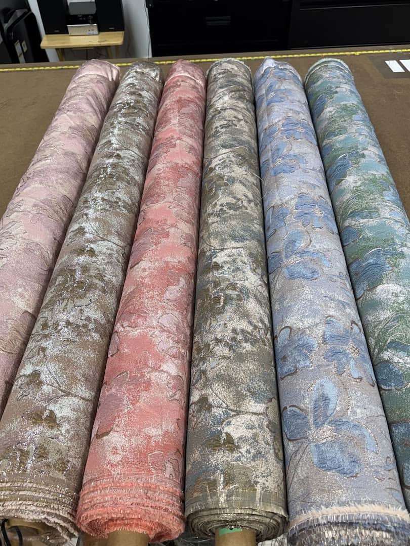 Rolls of floral satin fabric at Fabrictopia in Houston