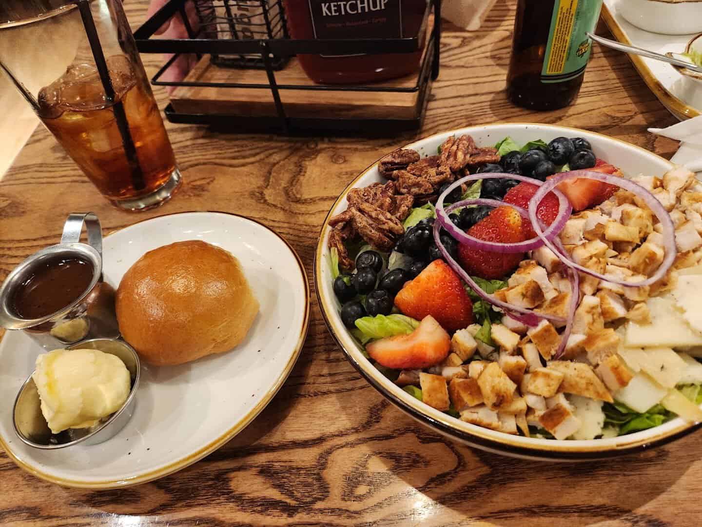 Farm-fresh lunch spread with salad, dinner roll and iced tea at Cafe Homestead in Waco, Texas