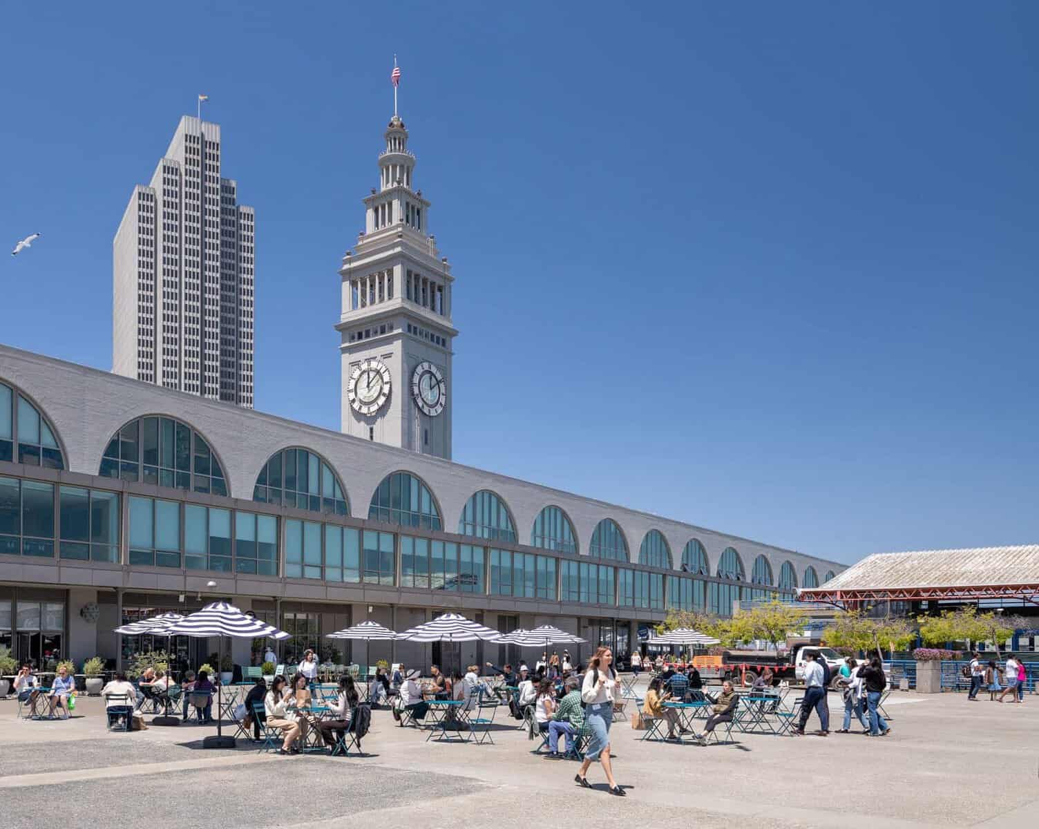 Ferry Building Marketplace clock tower in San Francisco with diners out front