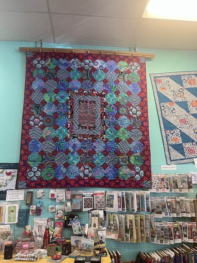 Finished quilts displayed on the wall at Quilt Country in Lewisville, Texas