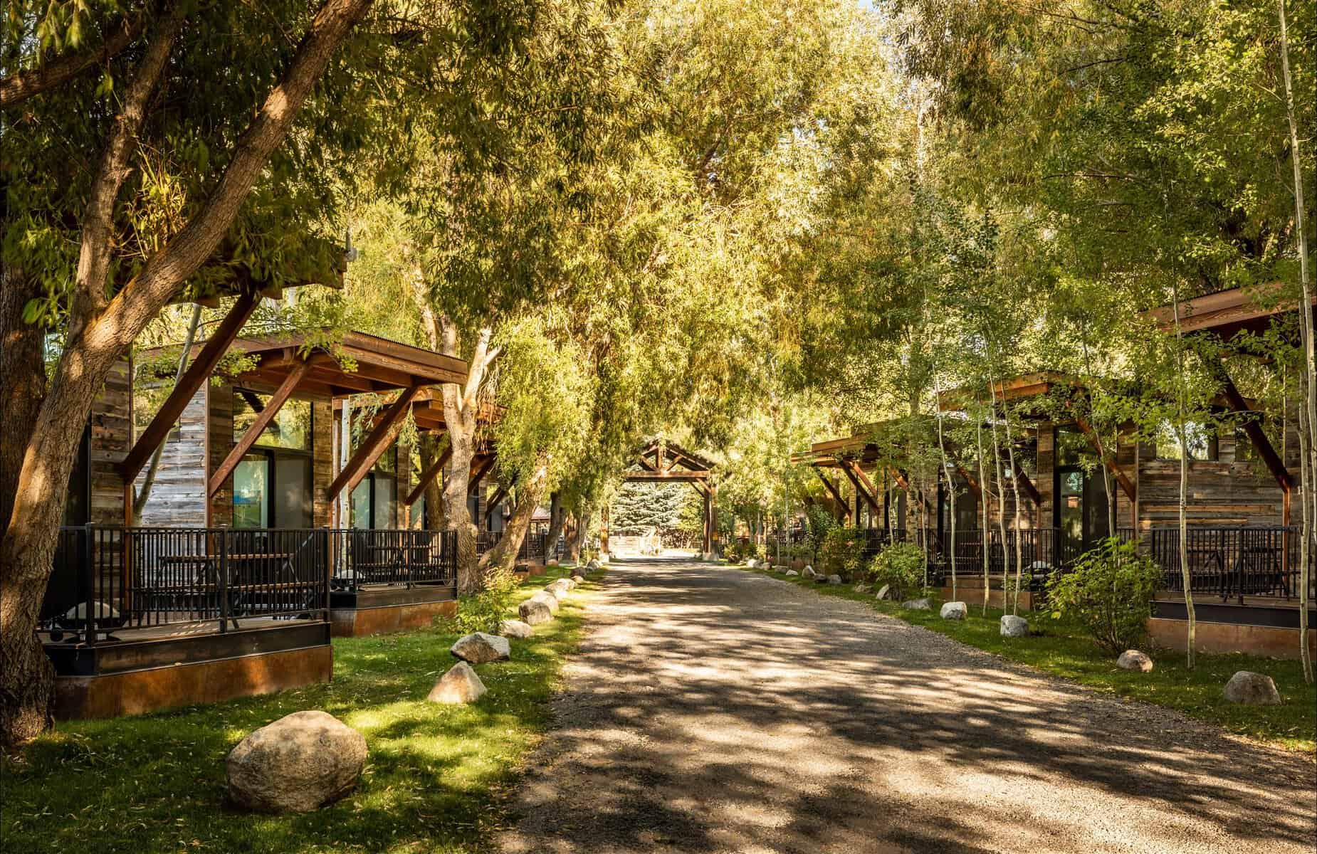 Reclaimed-wood Wheelhaus cabins along a wooded lane at Fireside Resort near Grand Teton, Wyoming