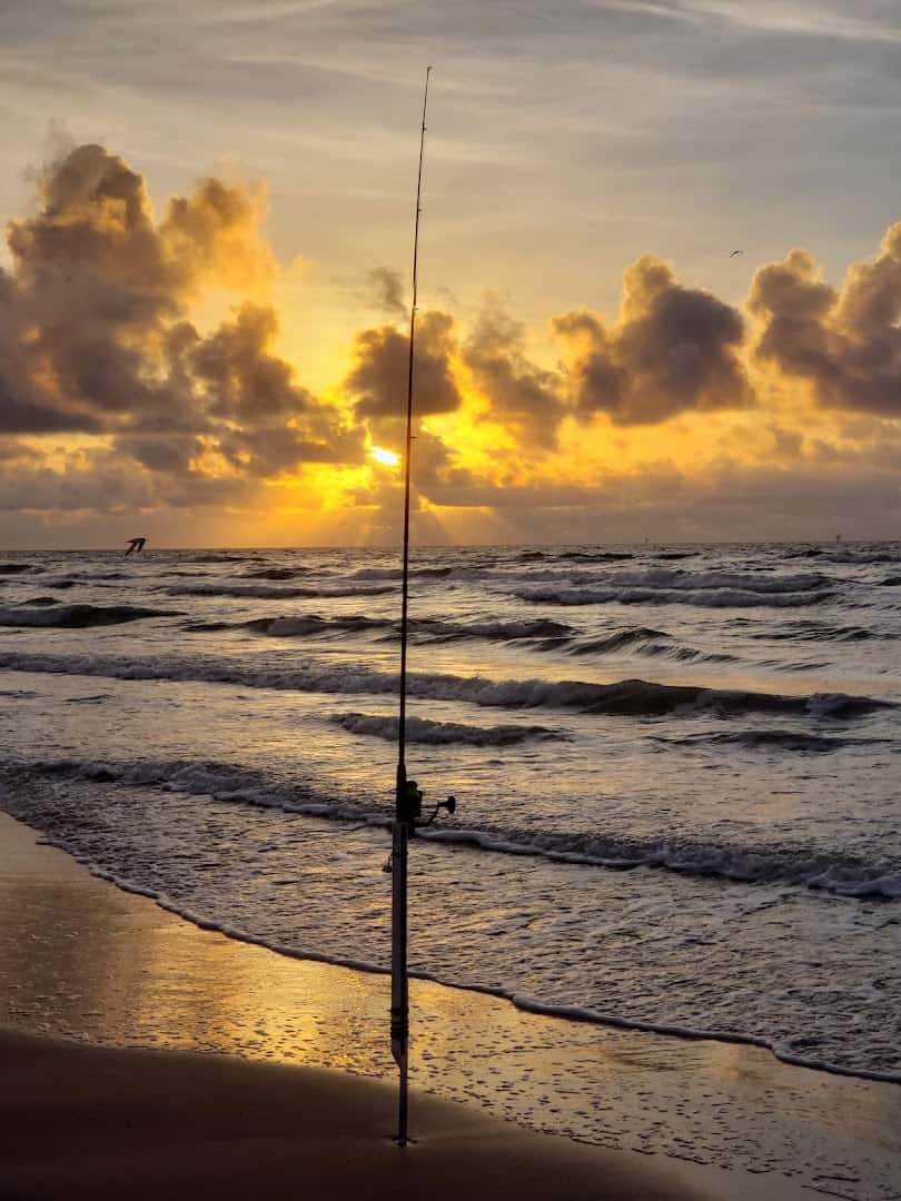 Fishing rod silhouetted against a Gulf sunrise at Mustang Island State Park, Texas