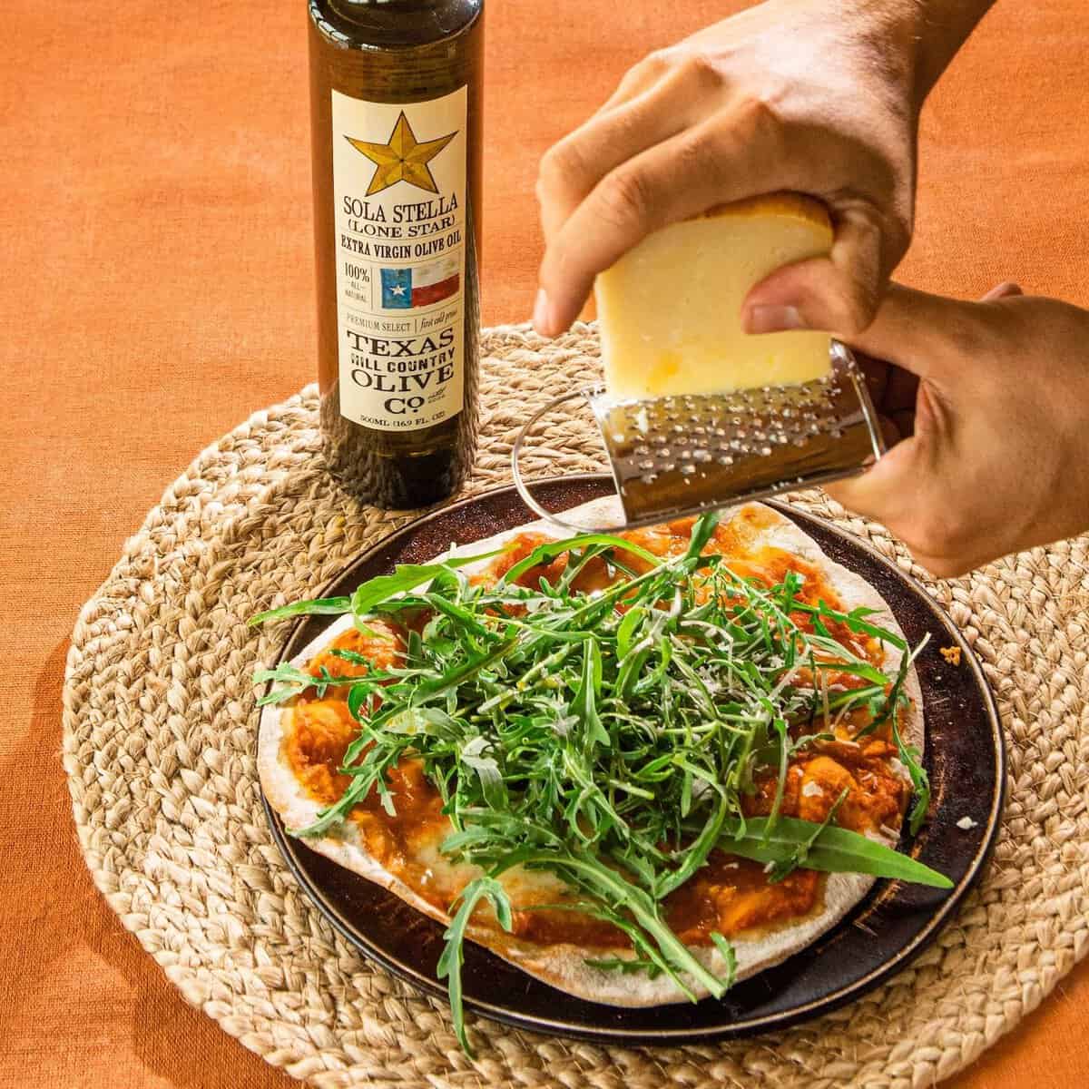 Flatbread with arugula and shaved cheese made with Texas Hill Country olive oil