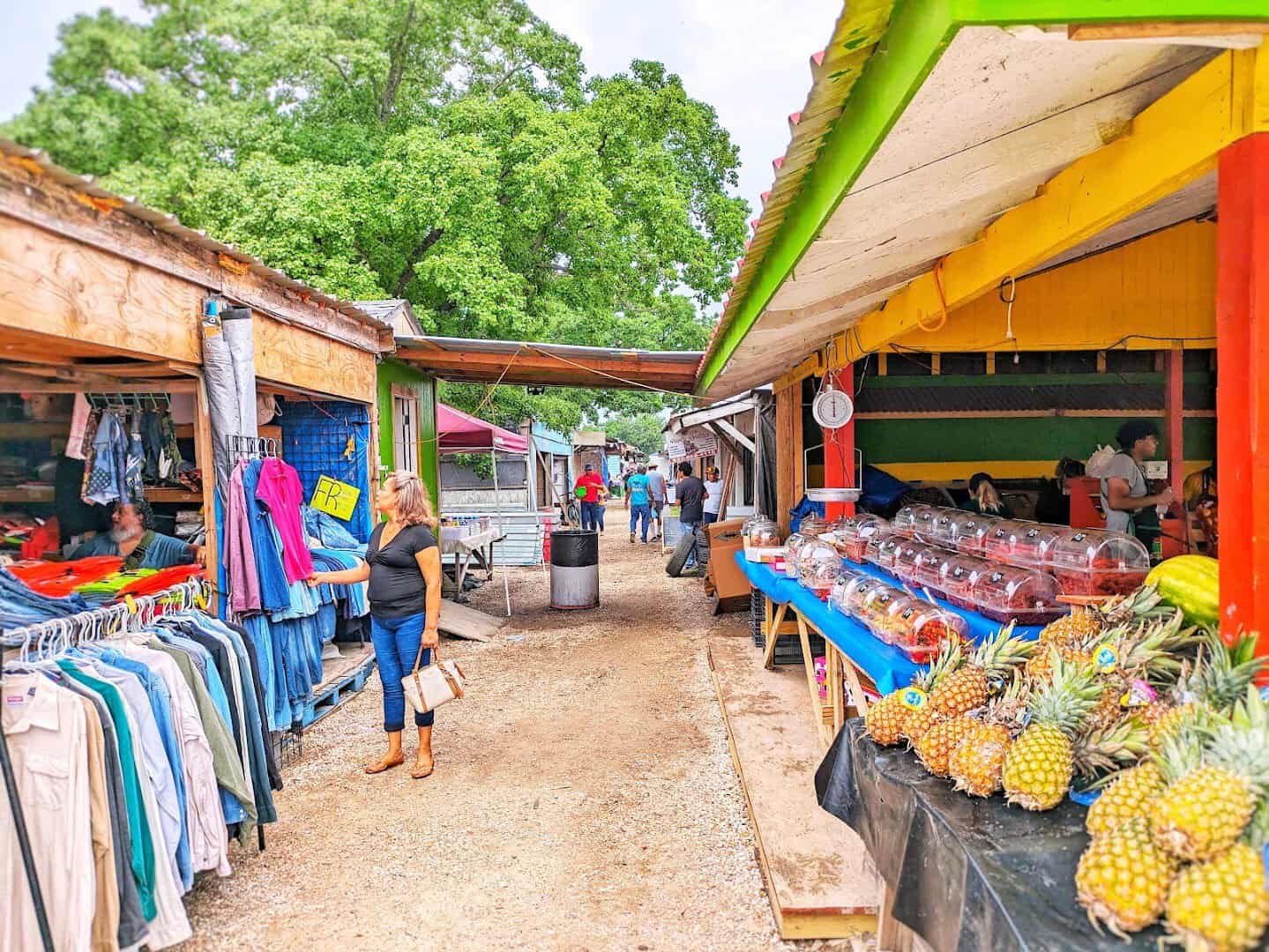 A covered aisle of brightly stocked vendor stalls at Cole's Antique Village in Pearland, Texas