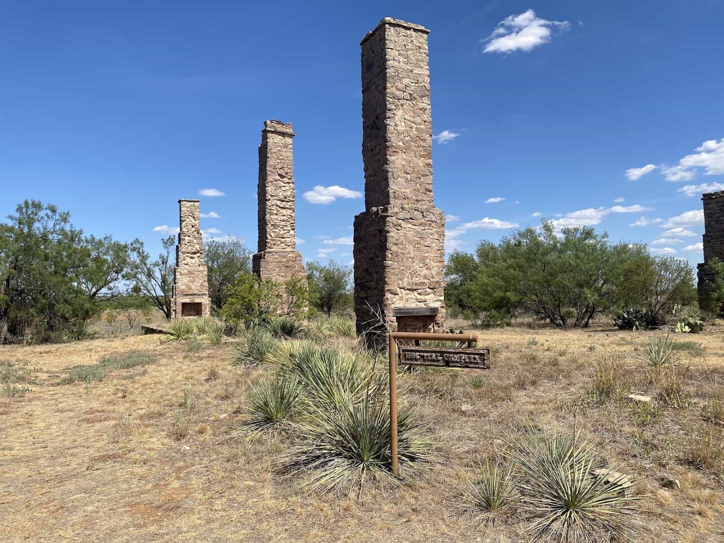 Twin stone chimneys standing at Fort Phantom Hill under a blue Texas sky