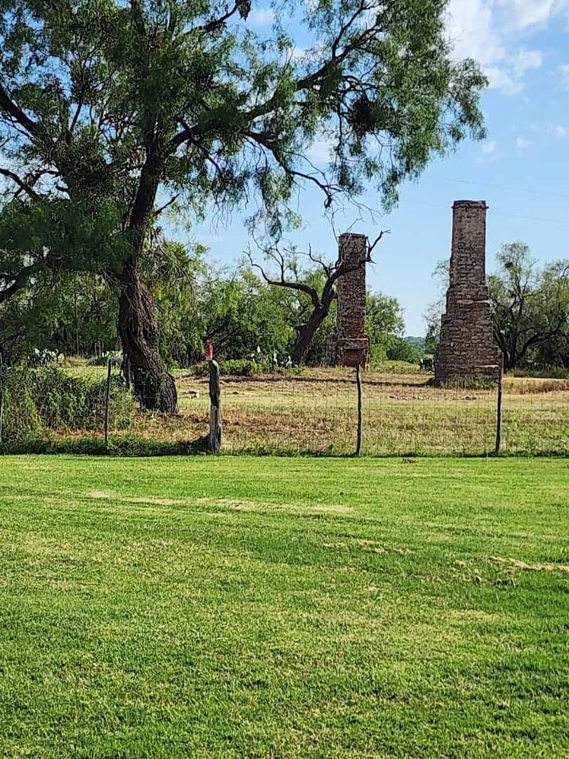 A lone stone chimney standing on the West Texas plains at Fort Phantom Hill