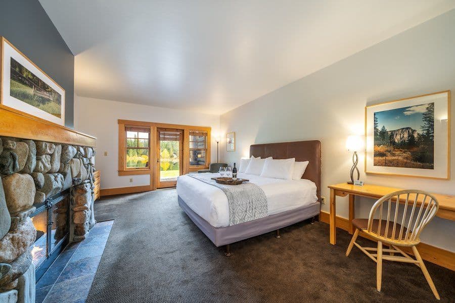 Cabin interior with stone fireplace and forest view at Freestone Inn in Mazama, Washington