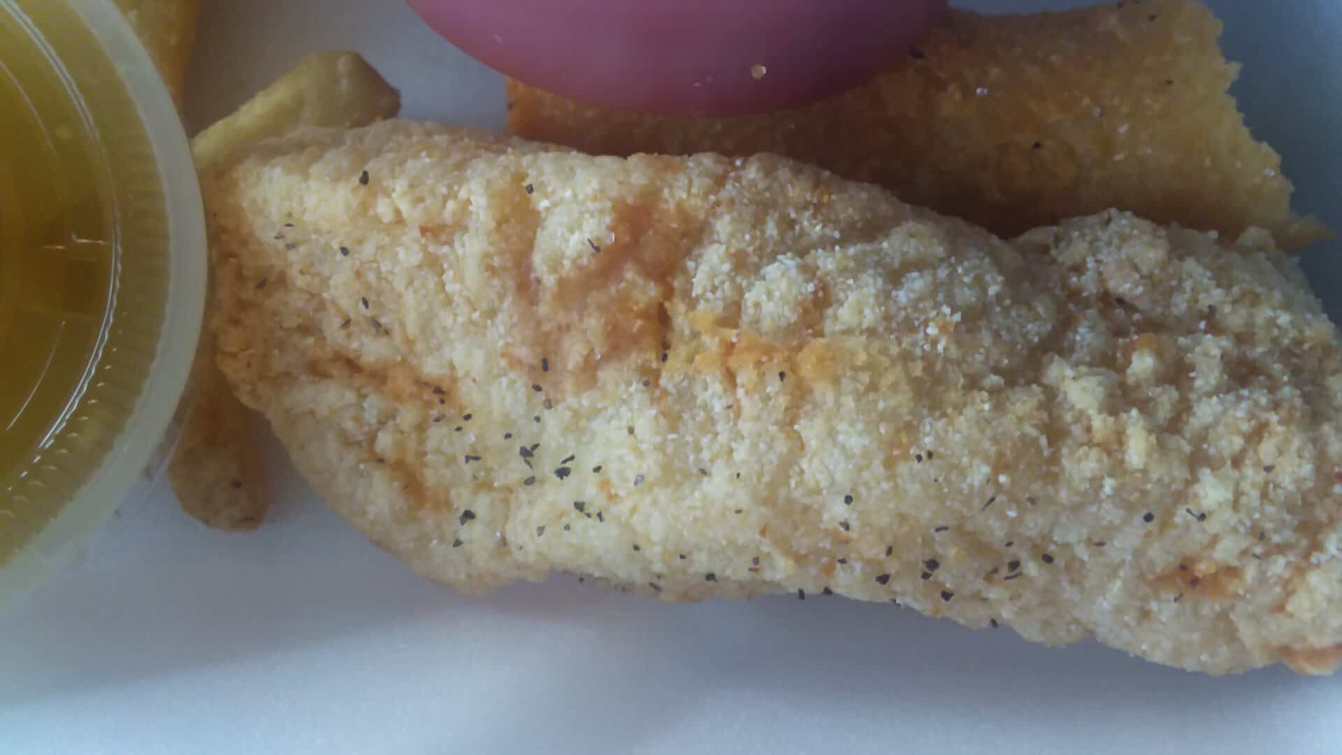 Close-up of a fried catfish fillet with peppered cornmeal crust at Catfish King in Waco, Texas