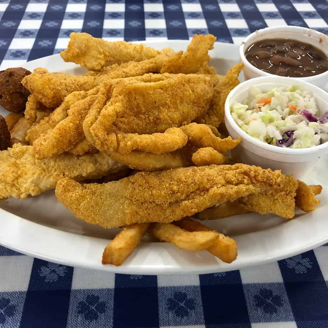 Golden fried catfish plate with hush puppies, fries, coleslaw, and pinto beans at the Farm House in Mexia, Texas