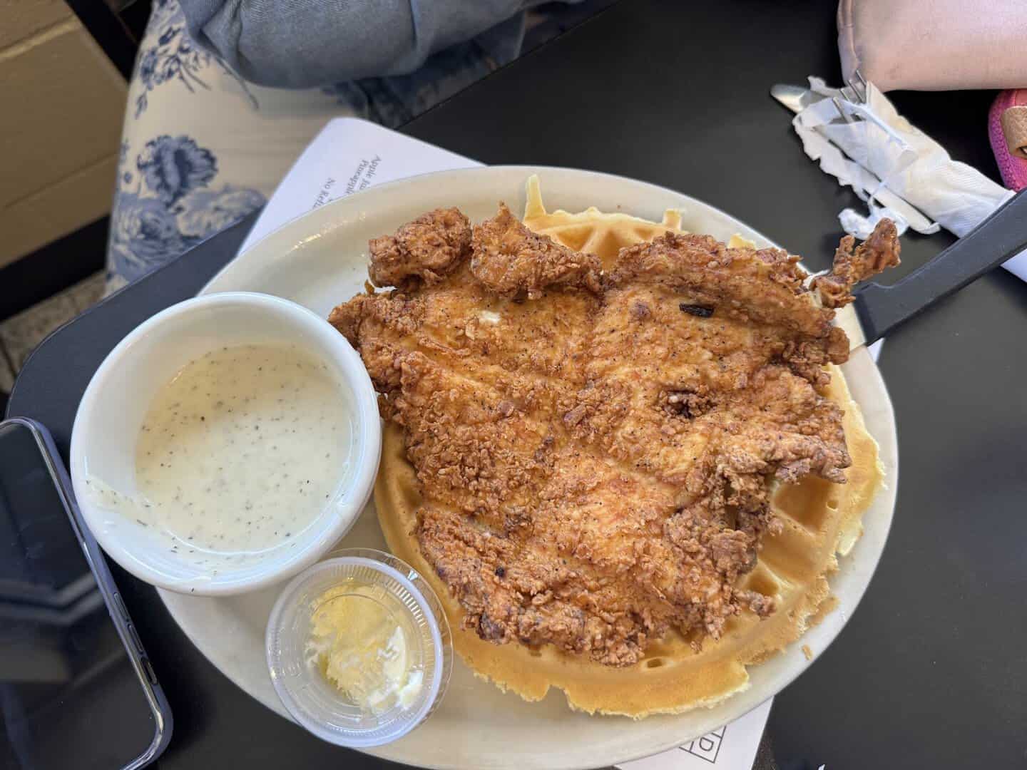 Golden fried chicken over a waffle with peppered cream gravy at Jonathon's Diner in Dallas