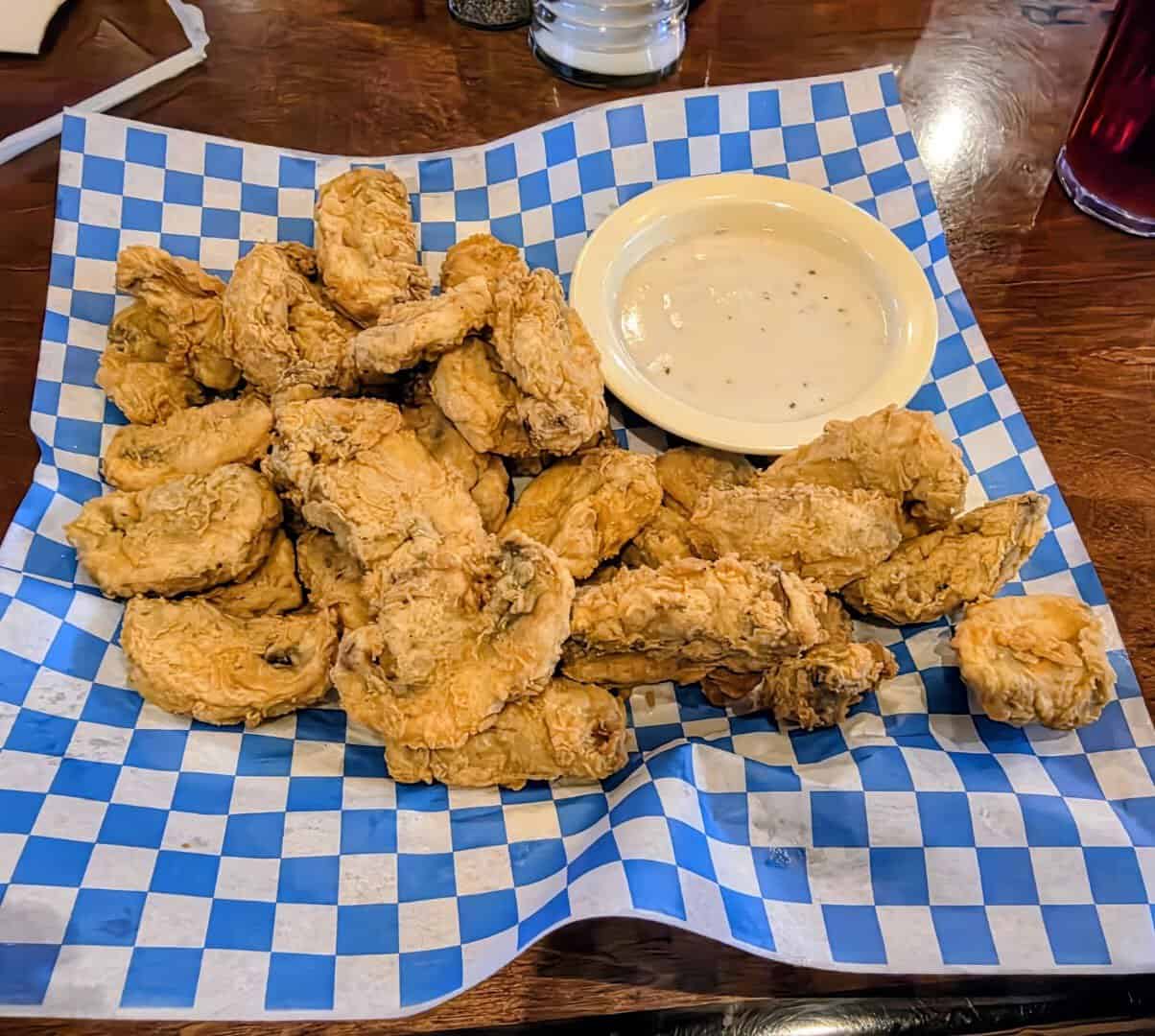 Basket of fried mushrooms with a bowl of cream gravy for dipping at Richter's Antler Cafe in Spring Branch, Texas