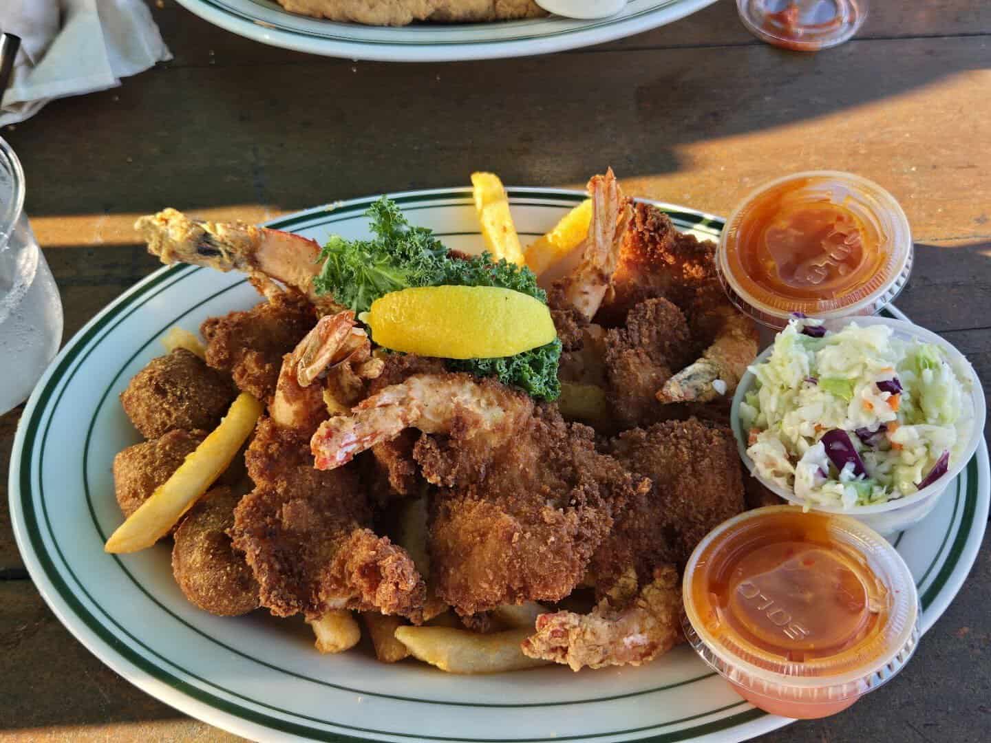 Fried shrimp and seafood platter with fries and hush puppies at Topwater Grill in San Leon
