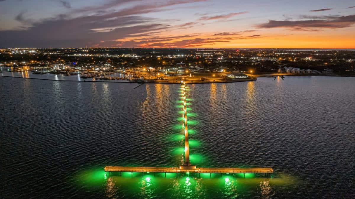 Fulton fishing pier lit by LED lights at night over Aransas Bay