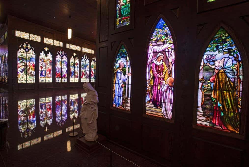 A wall of arched antique stained-glass windows glowing inside the Gelman museum