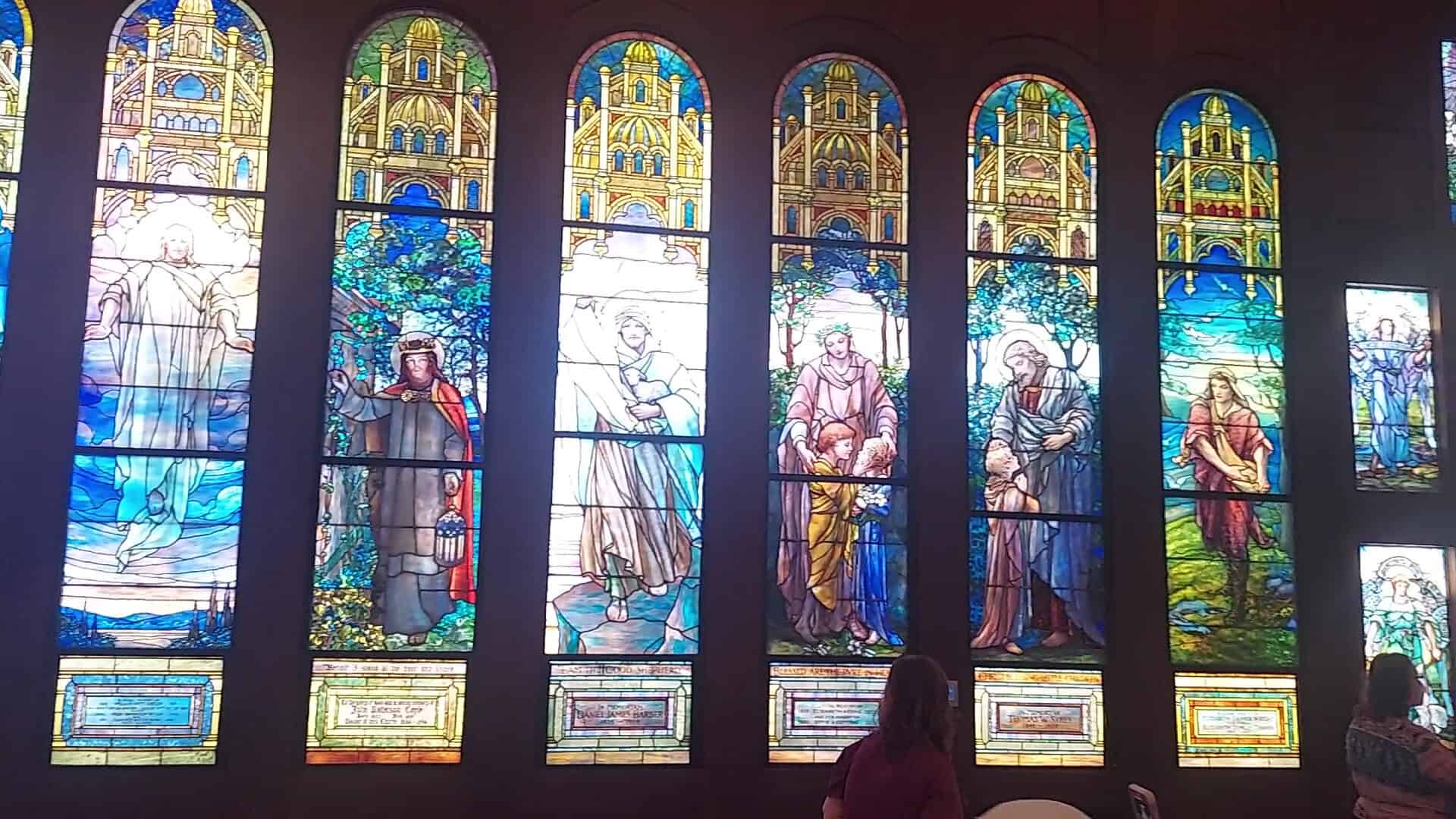 A row of figural Tiffany stained-glass windows showing biblical scenes