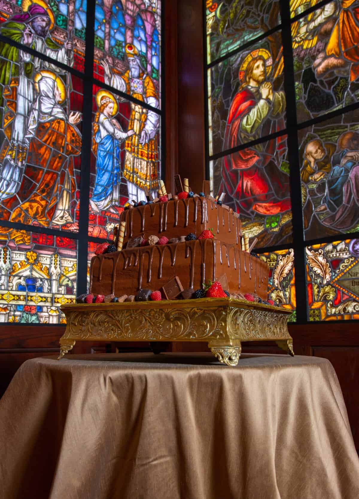 Large Tiffany-style figural stained glass window above an altar at the Gelman Stained Glass Museum