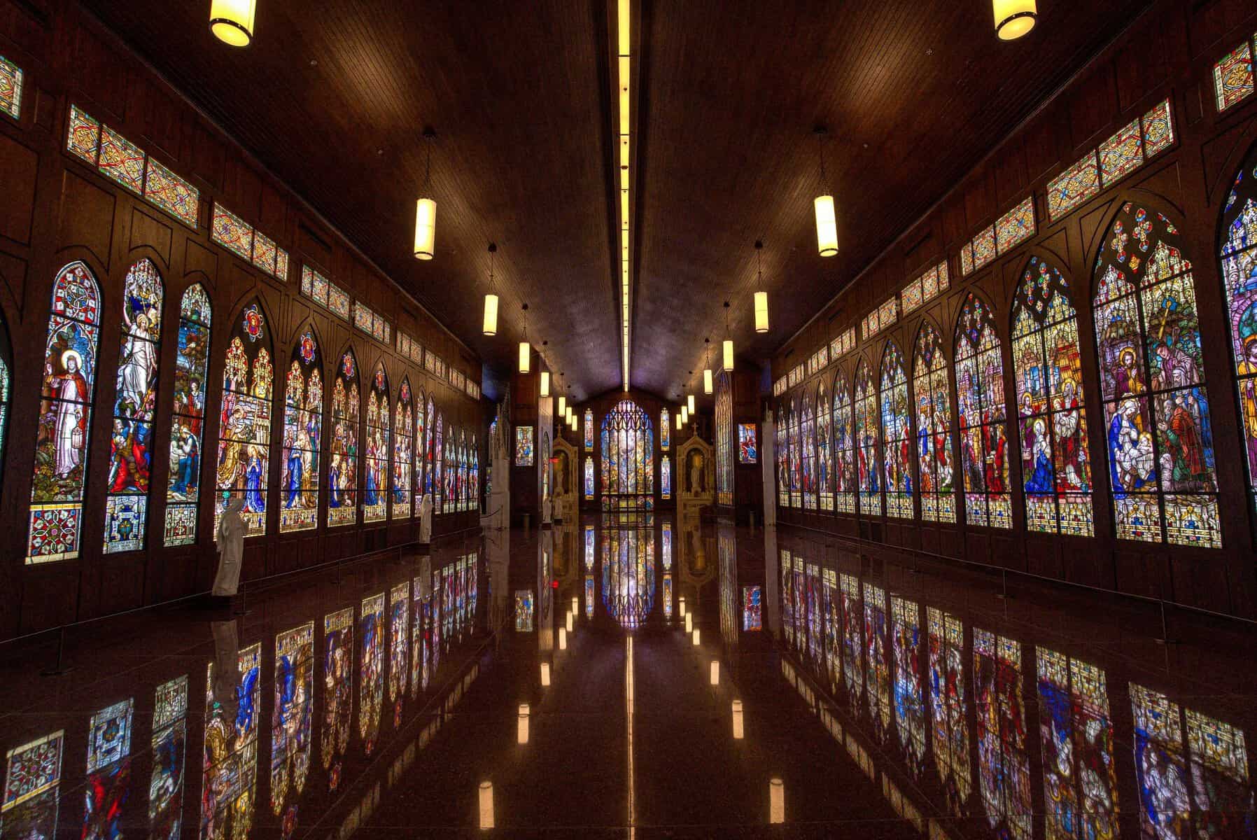 Long hall lined with antique stained glass windows at the Gelman Stained Glass Museum