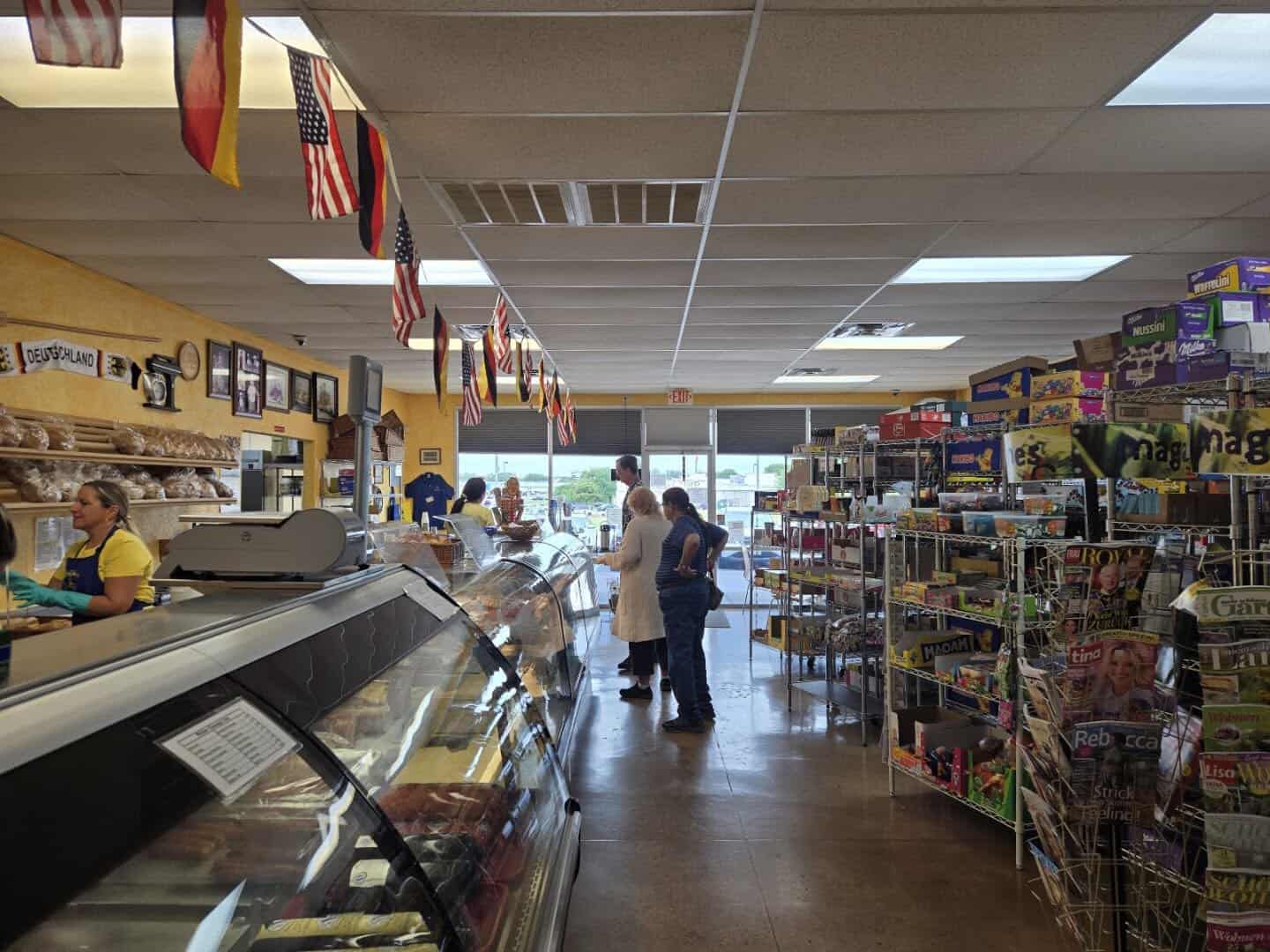 German grocery aisle beneath a German flag at Pfeifer's German Bakery and Deli in Harker Heights, Texas