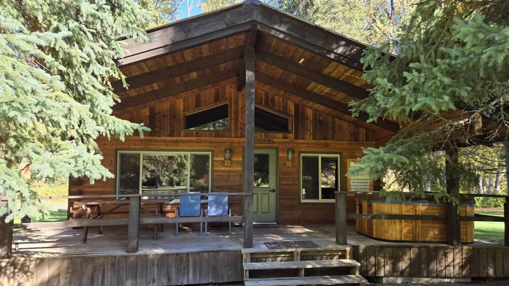 Log cabin with a barrel hot tub on the deck at Glacier Wilderness Resort near Glacier National Park, Montana