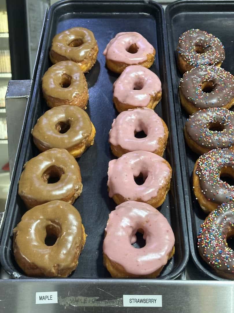 Glazed and strawberry sprinkle donuts in the case at Round Rock Donuts in Round Rock, Texas