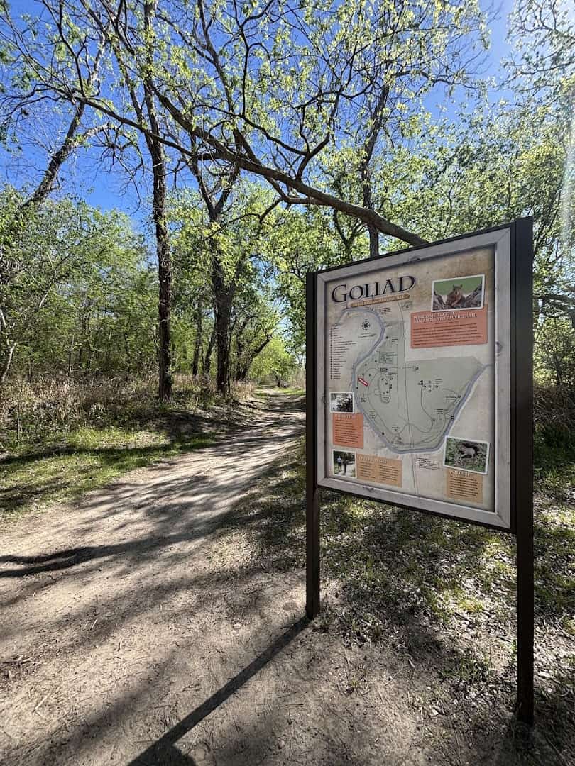 Wooded San Antonio River Trail with trail sign at Goliad State Park, Texas