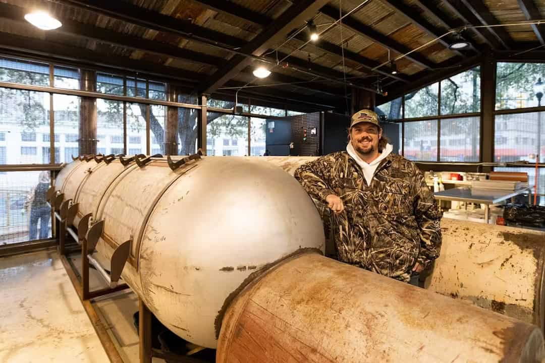Founder Grant Pinkerton standing by the offset smokers at Pinkerton's Barbecue