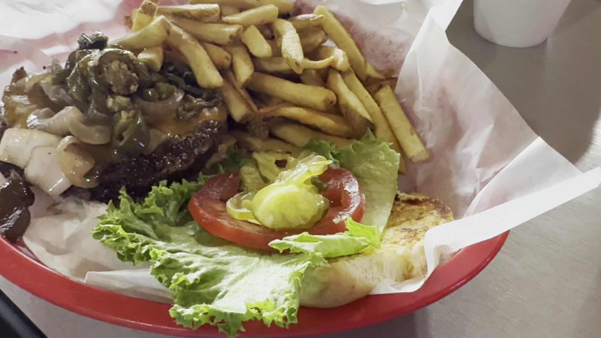 Green chili cheeseburger with grilled onions and fries at Roadhouse in Bastrop, Texas