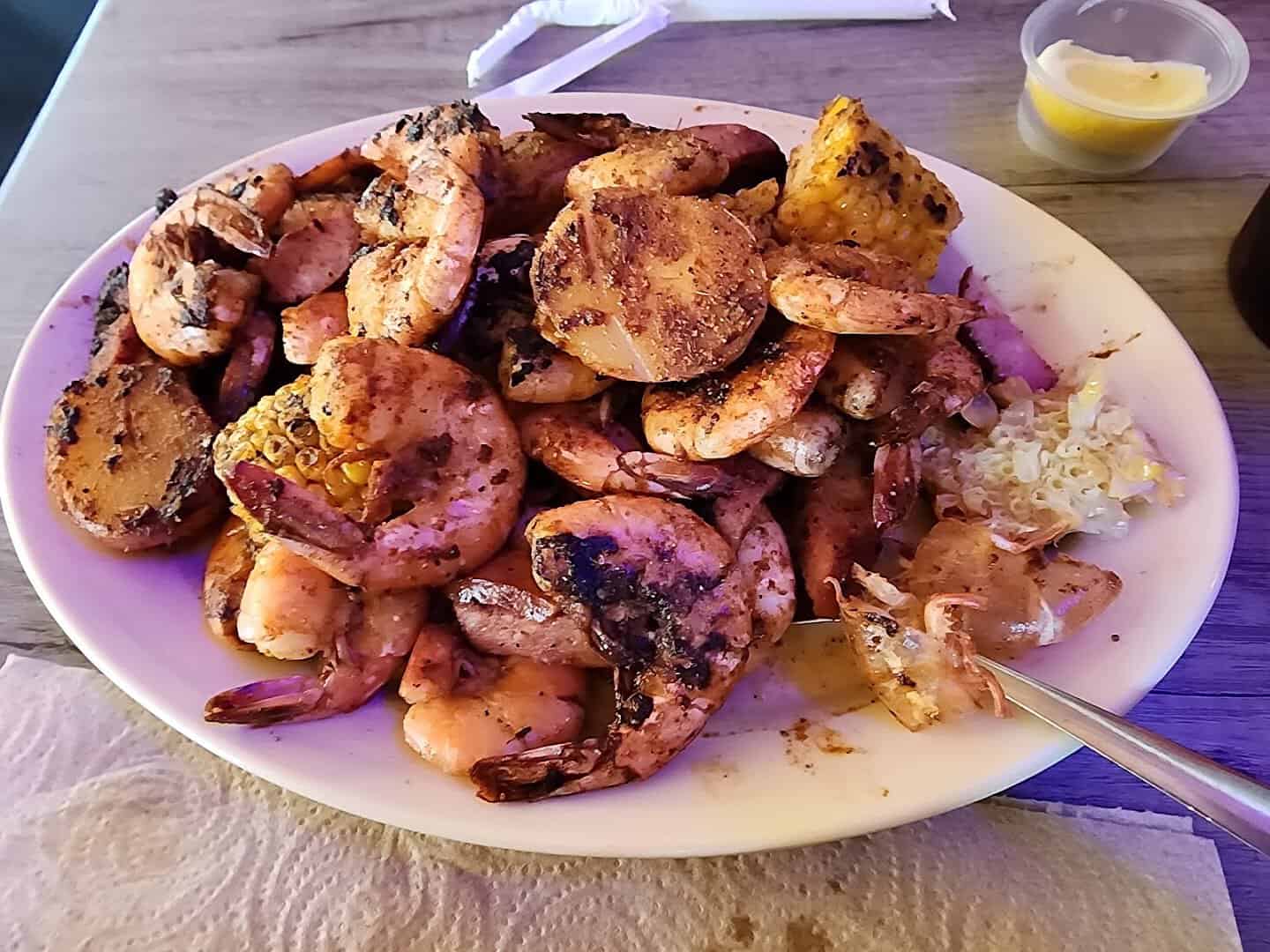 Platter of grilled seasoned shrimp, sausage and corn at Fish Shack in Plano, Texas