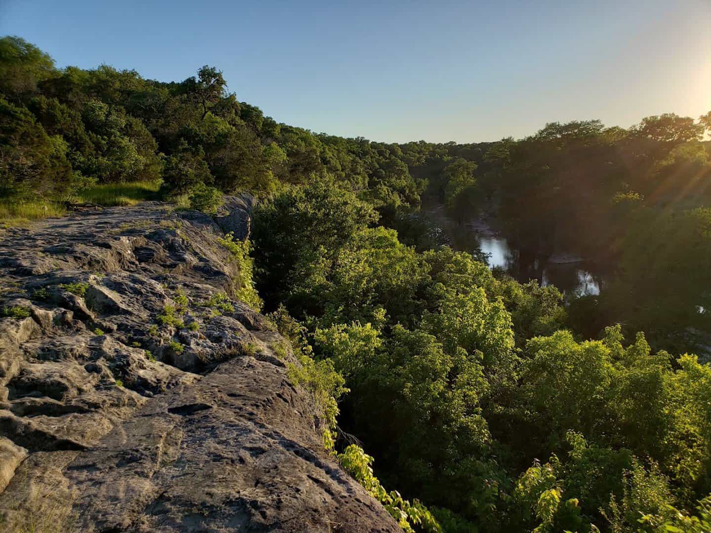 Bluff-top overlook of the wooded Guadalupe River canyon at golden hour
