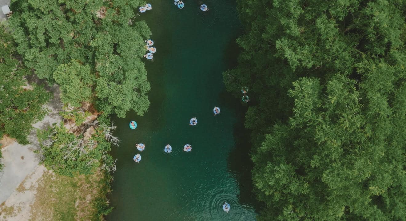 Tubers floating the Guadalupe River under cypress trees near Gruene, Texas