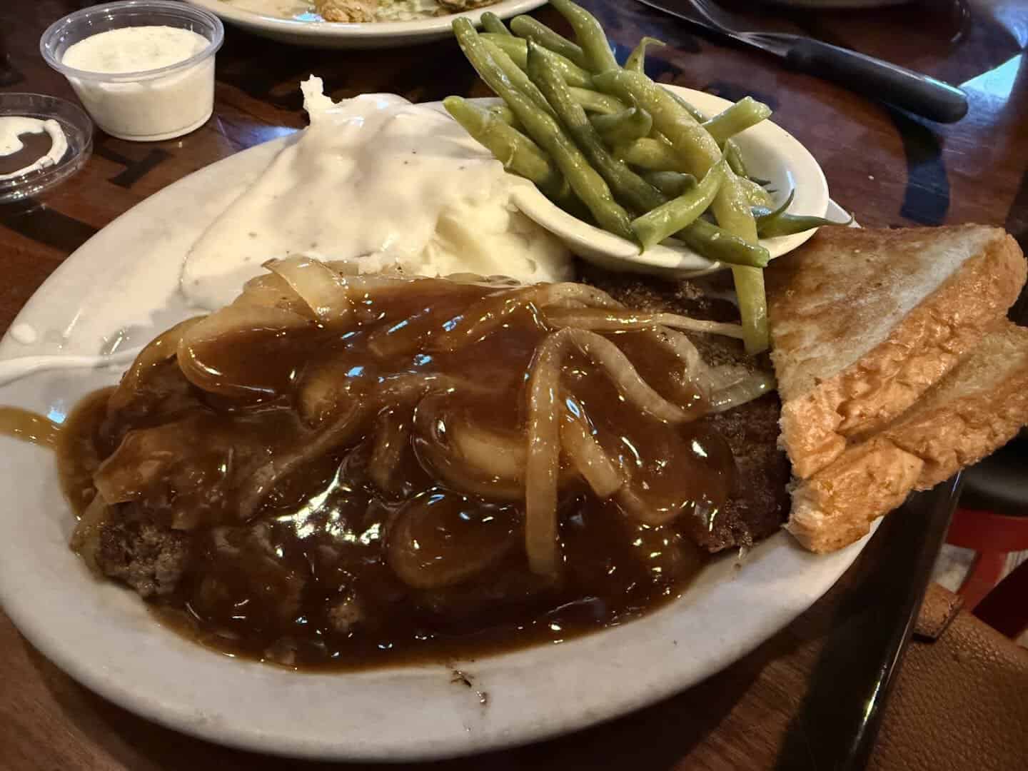 Hamburger steak smothered in onions and brown gravy with mashed potatoes, green beans and Texas toast at Richter's Antler Cafe in Spring Branch, Texas