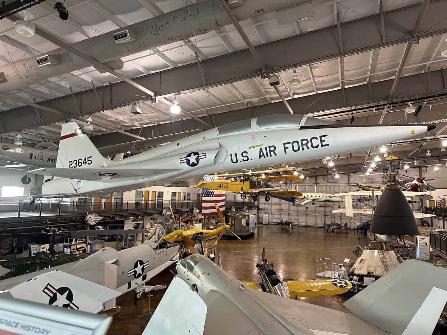 Vintage aircraft and biplanes filling a hangar at the Frontiers of Flight Museum in Dallas