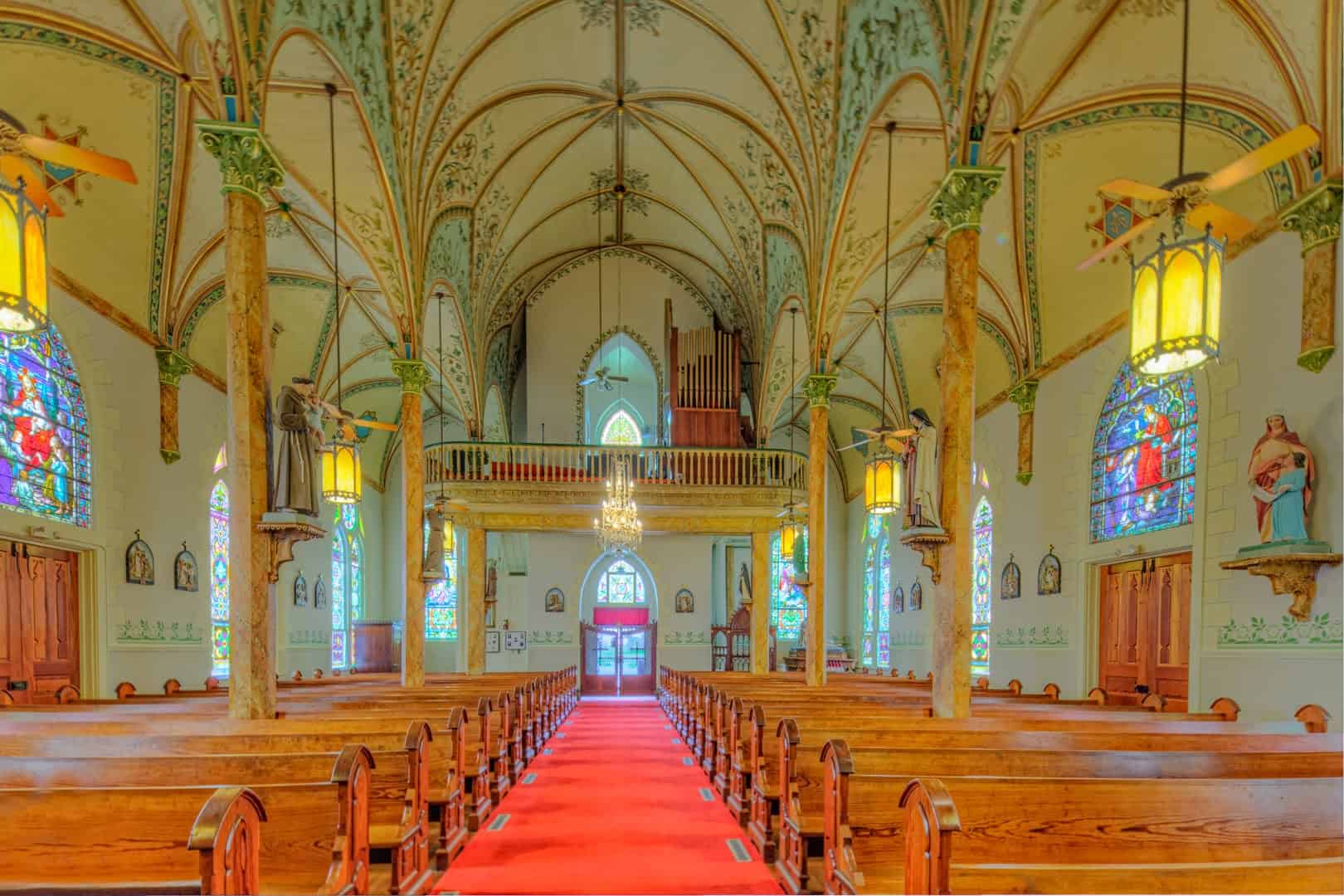 Painted gothic vaults, columns and stained glass in the High Hill church nave