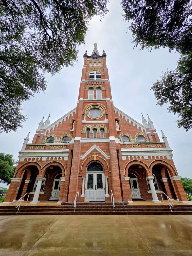 Red brick facade and tower of St. Mary's Catholic Church in High Hill, Texas