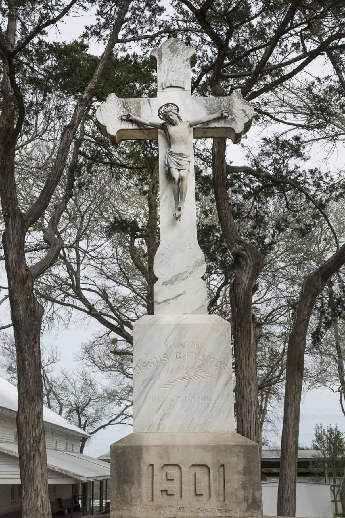 Marble churchyard crucifix dated 1901 outside St. Mary's Catholic Church in High Hill, Texas