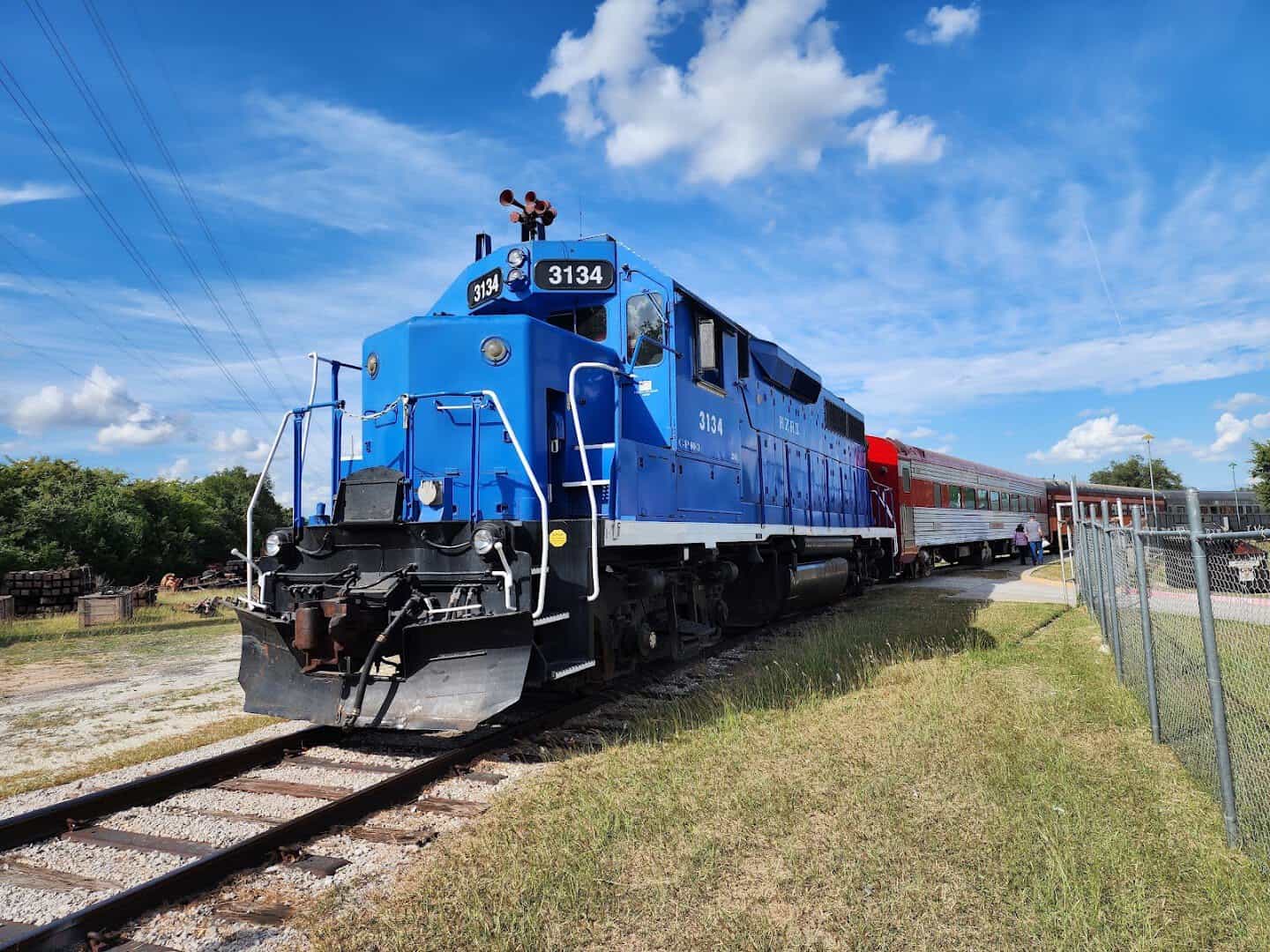 Blue diesel locomotive pulling the Hill Country Flyer at the Austin Steam Train, Cedar Park, Texas