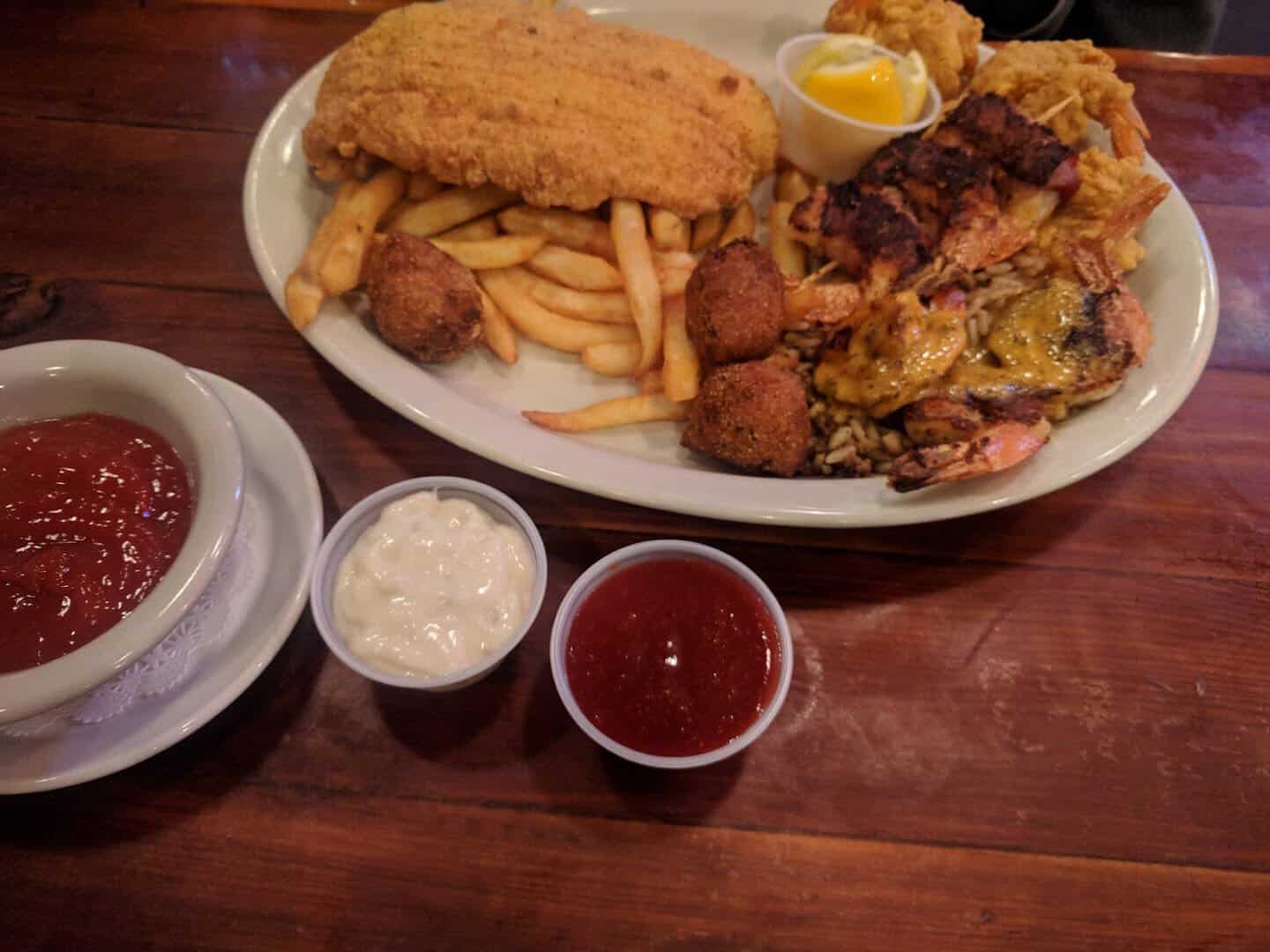 Seafood platter with fried catfish, shrimp, hush puppies and fries at Hofbrau Steaks in Porter, Texas