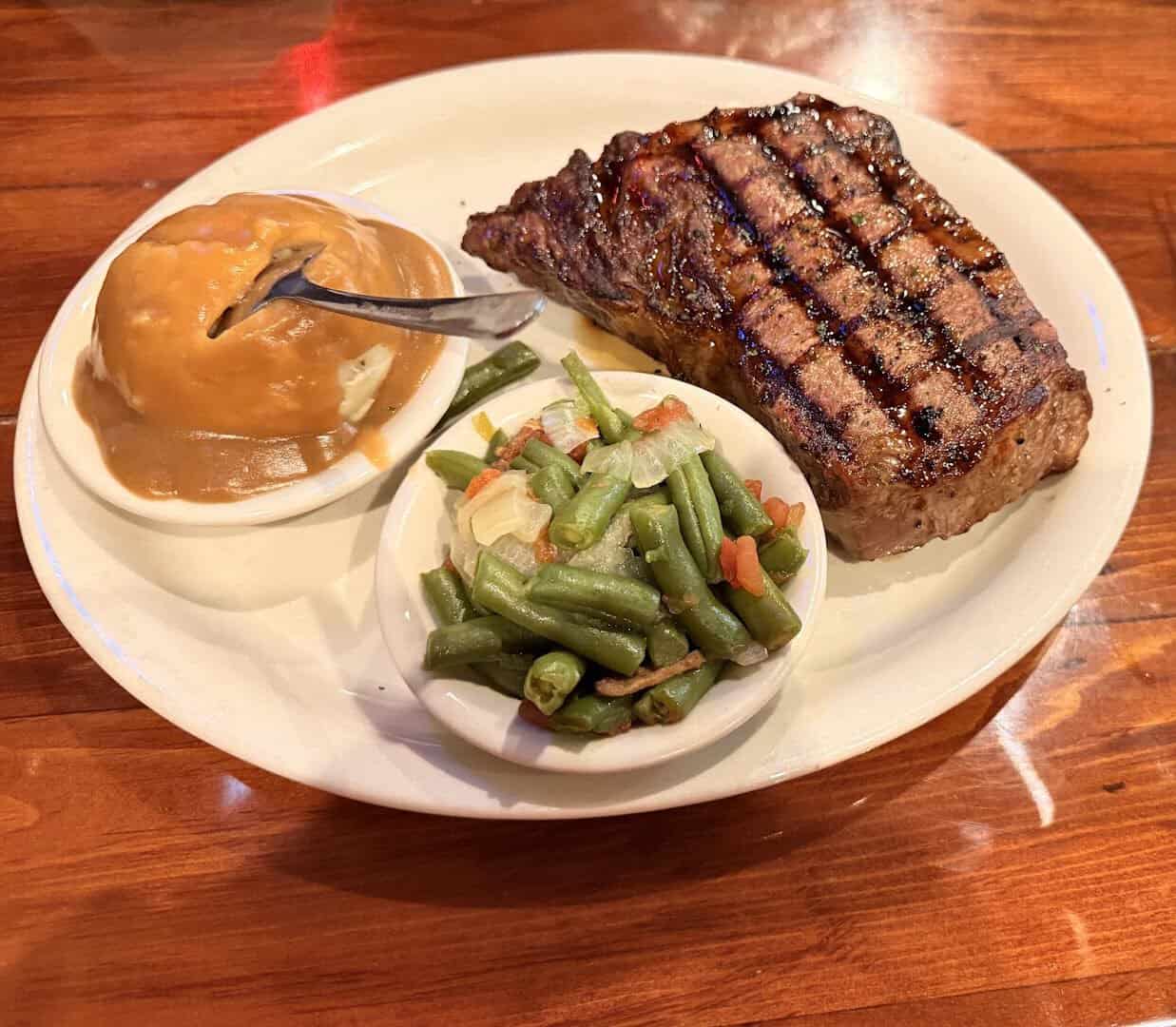 Strip steak with mashed potatoes and green beans at Hofbrau Steaks in Porter, Texas