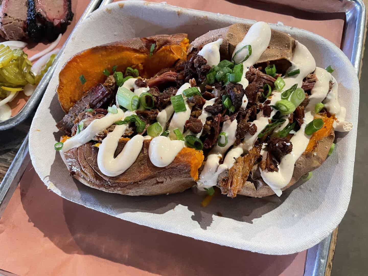 The Hot Mess loaded sweet potato with barbacoa and chipotle cream at Pecan Lodge in Dallas