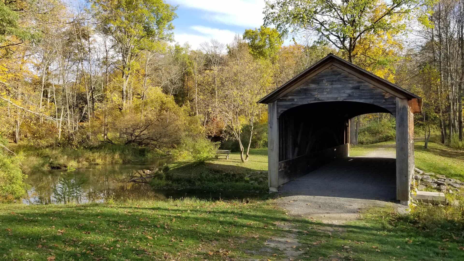 Hyde Hall Covered Bridge over Shadow Brook in fall, Glimmerglass State Park, New York