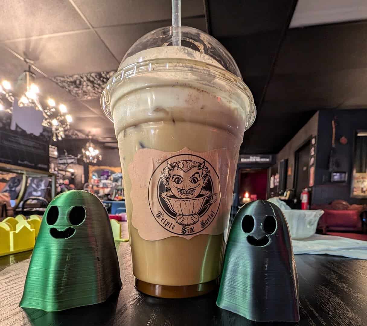 Iced latte with playful ghost figures at Triple Six Social