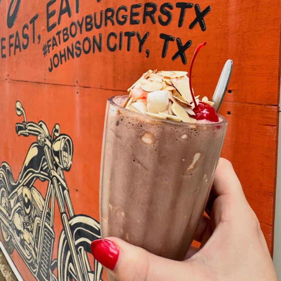 A loaded milkshake in front of a Johnson City, Texas mural