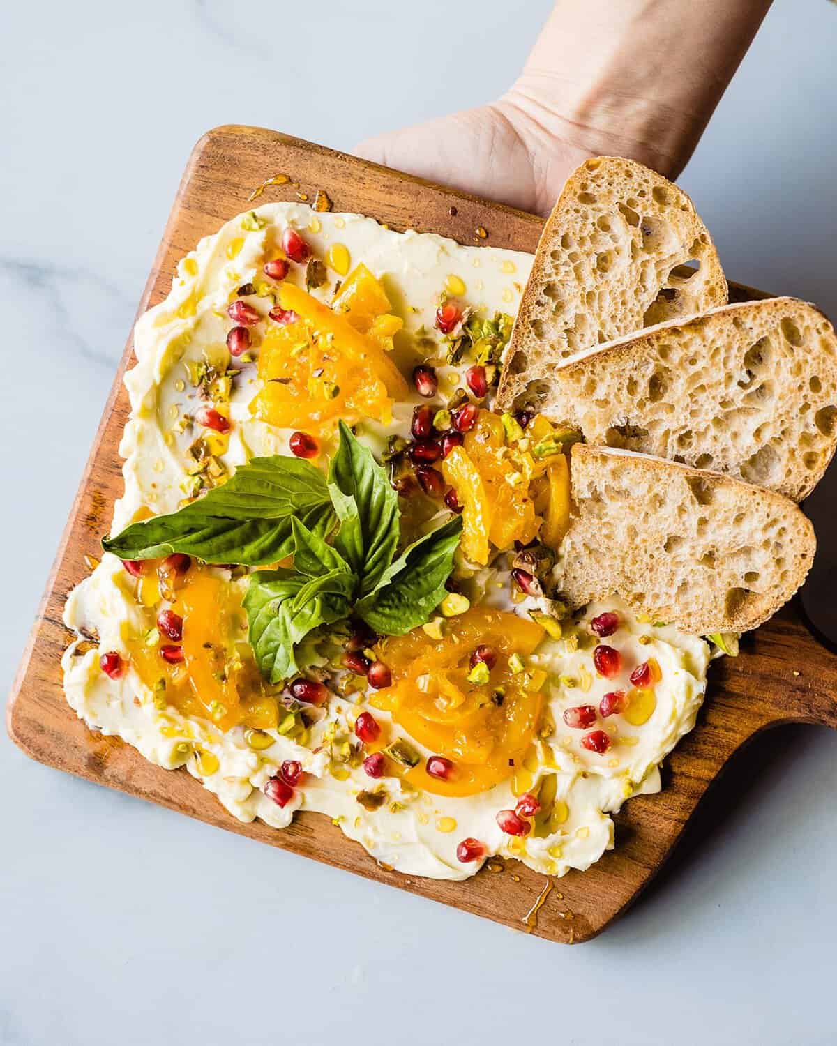 A whipped ricotta board with bread and pomegranate at a Johnson City, Texas eatery