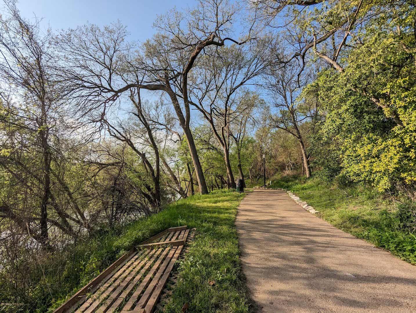The paved June Hill Pape Riverwalk path along the Colorado River in Bastrop, Texas