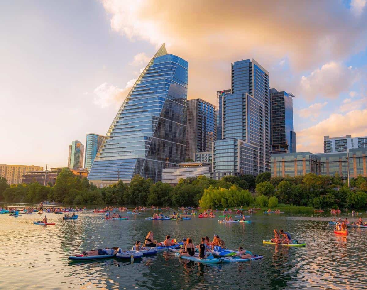 Kayaks and paddleboards on Lady Bird Lake below the downtown Austin skyline