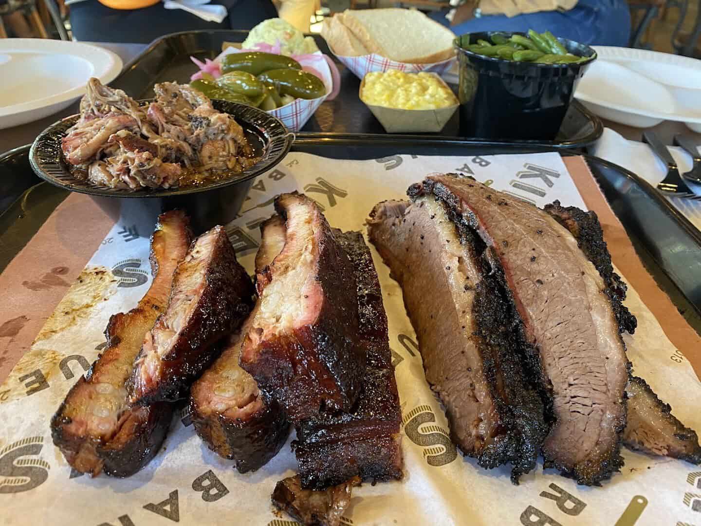 A brisket and pork rib platter with sides at Killen's Barbecue in Pearland, Texas