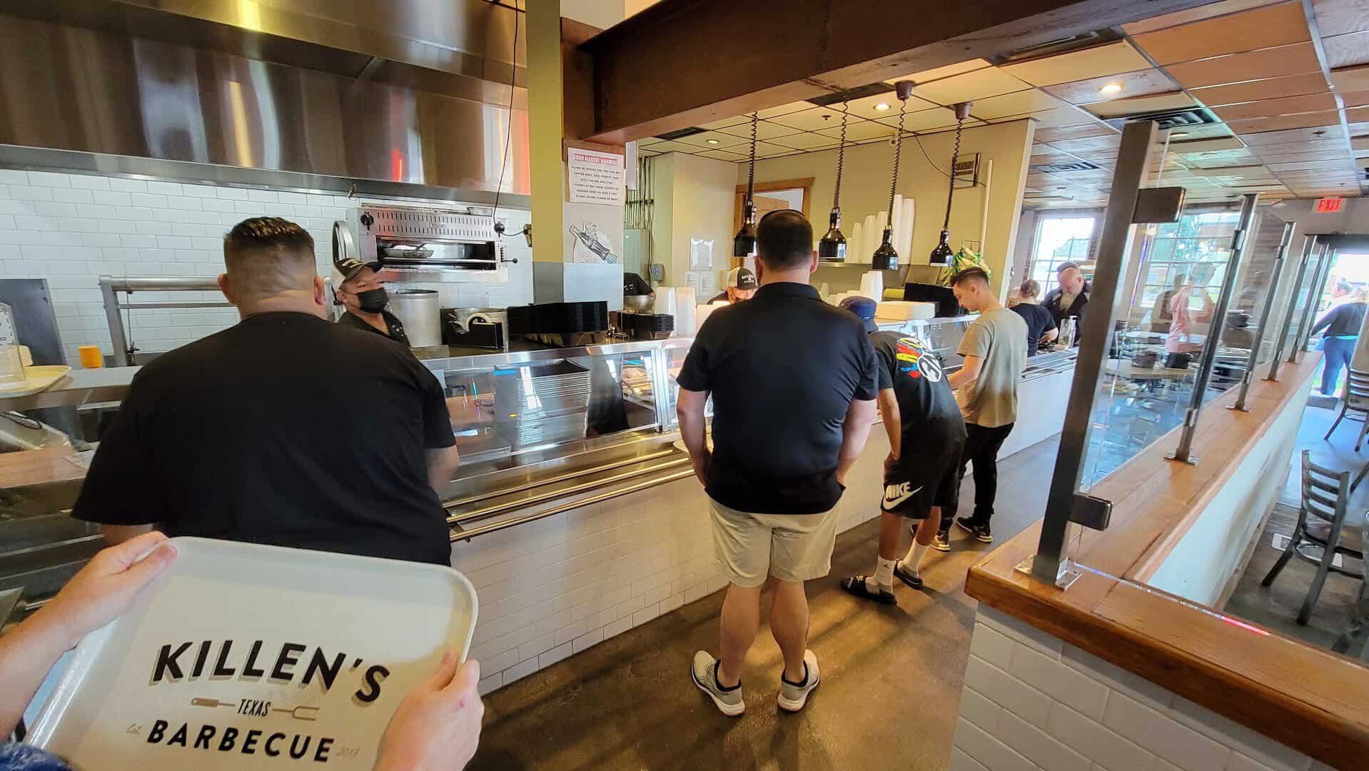 Guests moving along the cafeteria-style serving line at Killen's Barbecue in Pearland, Texas