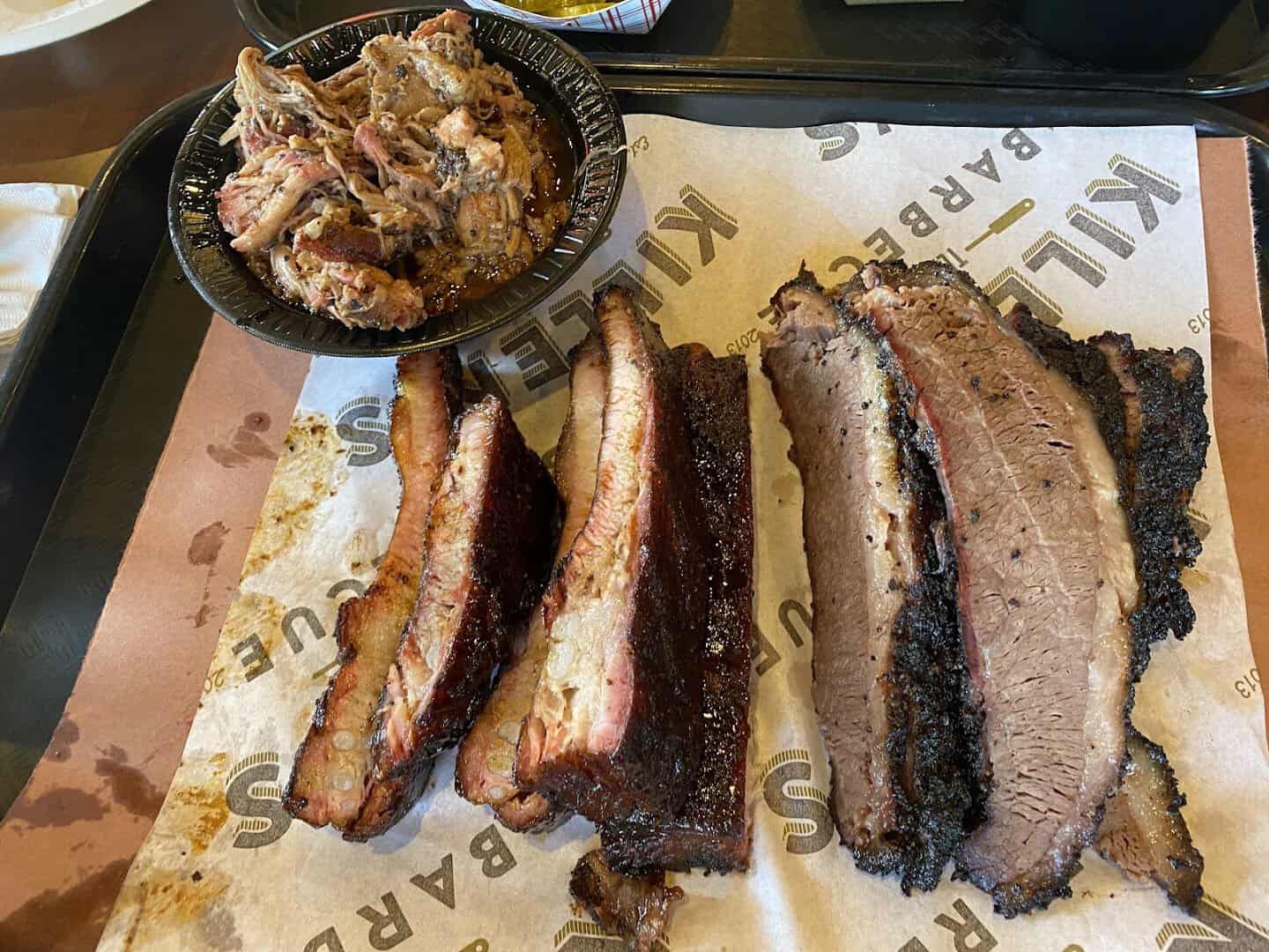 Smoked ribs and sliced brisket on butcher paper at Killen's Barbecue in Pearland, Texas