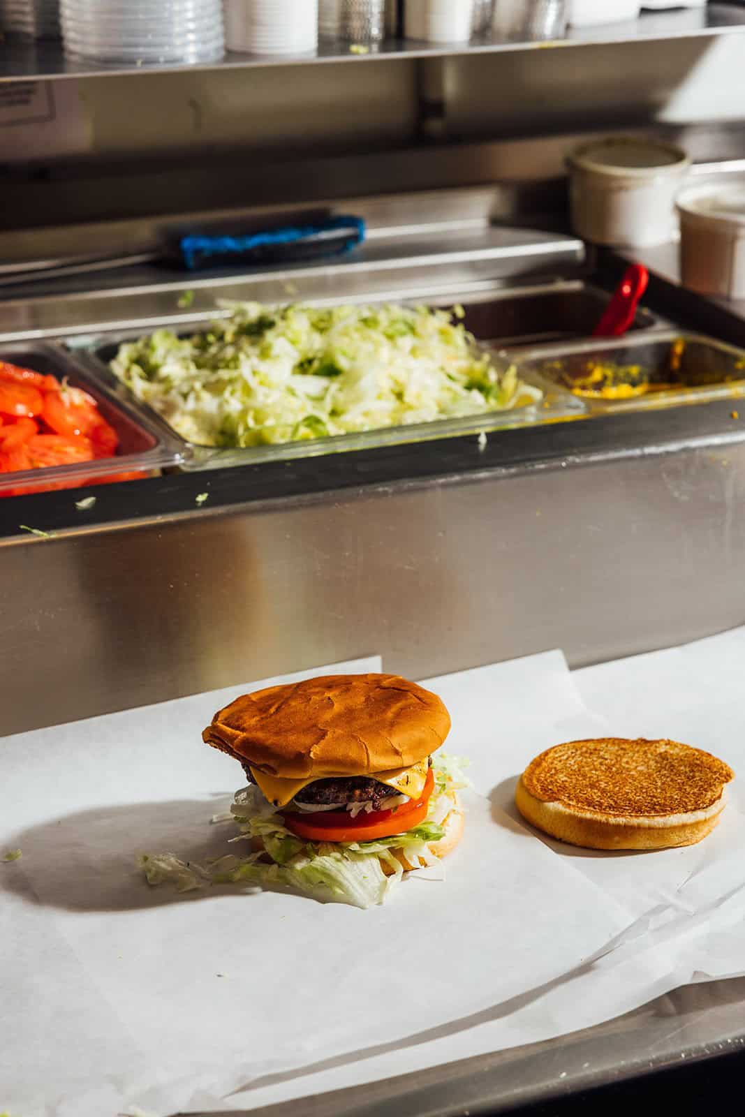 Fresh lettuce, tomato and toppings on the burger build line at Kincaid's Hamburgers in Fort Worth
